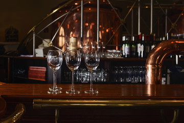 Glass glasses stand in anticipation of a party on the bar with a beautiful elegant interior.