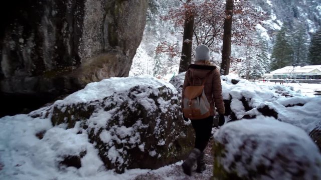 Young woman walking along Blausee lake in Switzerland during winter