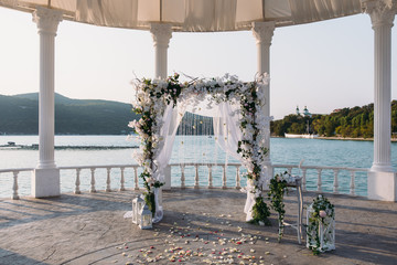 Wedding ceremony arch it the beautiful lake place. Details of decoration