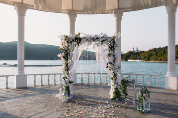 Wedding ceremony arch it the beautiful lake place. Details of decoration