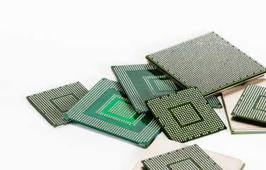 Computer electronic chips isolated on white arranged in a stack. The chips are placed upside down or facing the viewer. there are different chips in the stack