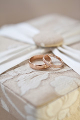Two wedding gold rings beige box with patterns