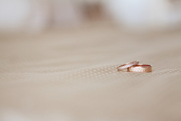 Two wedding gold rings beige background. Wedding jewelry