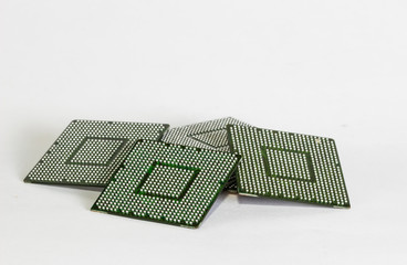 Computer electronic chips isolated on white arranged in a stack. The chips are placed upside down...