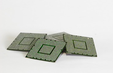 Computer electronic chips isolated on white arranged in a stack. The chips are placed upside down...