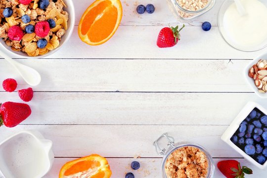 Ingredients for a healthy breakfast  forming a frame over a white wood background. Top view. Copy space.