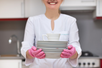 Smiling woman holding porcelain plates