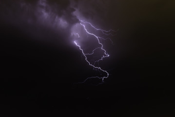 lightning bolts reflection over the sea. taken during a thunderstorm over the ocean with clouds in...