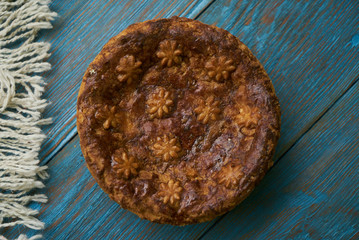 Round Loaf Karavai on wooden rustic table background. Traditional slavic russian and ukranian festivals and weddings bread, close-up