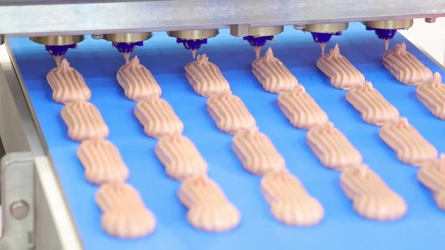 Cooking many sweet meringue on blue production line. sweet food concept.
