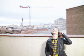 young boy with smartphone and headphones in the street