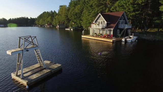 aerial kid swims to floating tower on lake