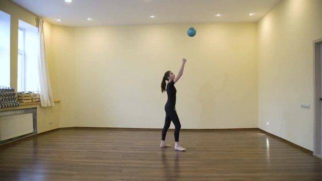 sports lifestyle. gymnastics calisthenics ball practice. exercise training balance perfecting. young beautiful teen girl in a gym