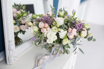 Sunny spring morning in living room. Beautiful luxury bouquet of mixed flowers in glass vase on wooden table. the work of the proffesional florist at a flower shop.