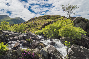 From Llyn idwal a waterfall runs down the mountainside at Cwm Idwal located in the Nant Ffrancon Valley.