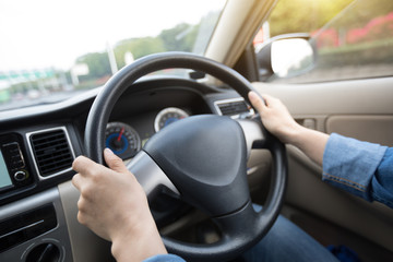 Hands on wheel driving car in city