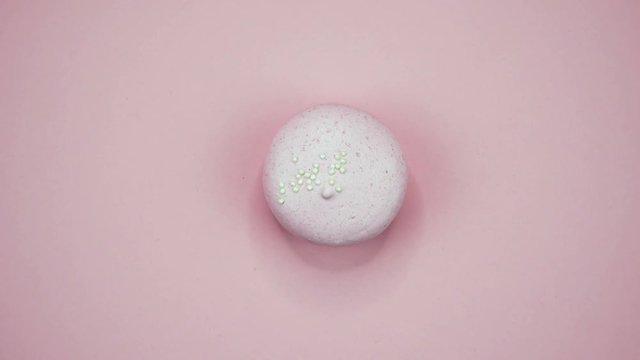 ROTATION: A Colorful Macaroons are rotating on a pink background