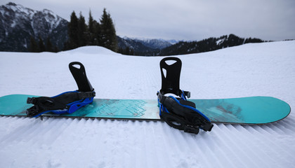  snowboard on ski piste in winter mountains