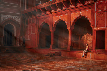 young guy sitting under the rays of the morning sun and watching the Taj Mahal mosque - obrazy, fototapety, plakaty