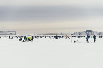 Fishermans on ice. Mans fishing on ice on gulf on Finland near Kronshtadt, Saint Petersburg, Russia,