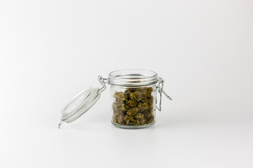 Weed buds in glass jar isolated on white