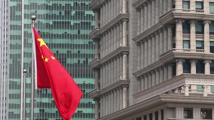 The Chinese flag flies in a business district in Shanghai, China. - Powered by Adobe