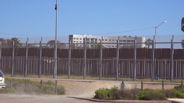 A Border Patrol vehicle passes in front of the border wall between San Diego and Tijuana.