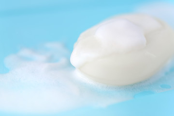 Fototapeta na wymiar Soap foam bubbles on blue background macro close up.