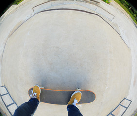 skateboarder legs riding skateboard at skatepark
