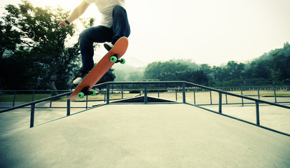Young skateboarder legs skateboarding at skatepark © lzf