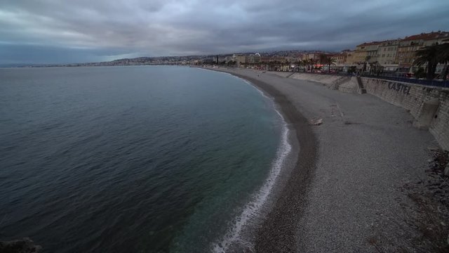 Evening on Nice promenade anglais with sea and waves on Mediterranean sea