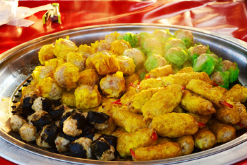 yellow ,green and black shumai in metal tray for sale at walking street market