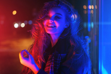 Sexy young woman posing over night city dramatic neon background
