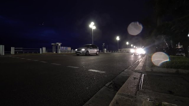 Cars drive on night city street and many headlights