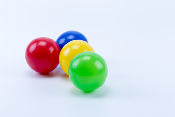 Four colored plastic balls of game room swimming pool for fun and jumping, red, green, yellow and blue.