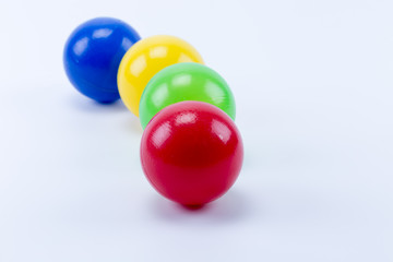 Four colored plastic balls of game room swimming pool for fun and jumping, red, green, yellow and blue.
