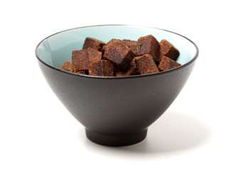 brown cubes of sugar on white background