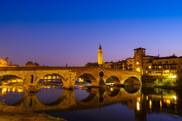 The Ponte Pietra has the Adige River at night