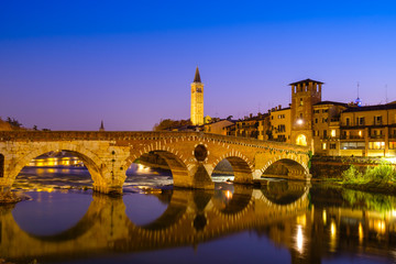 The Ponte Pietra has the Adige River at night