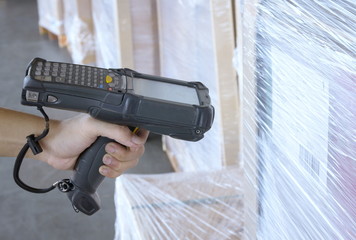 Warehouse worker hand holding barcode scanner with scanning on product.