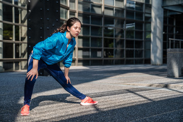 Fototapeta premium Woman runner stretching legs before workout
