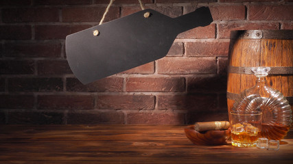 Glass of cognac with barrel on brick backgroun