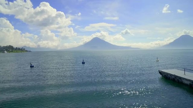 Aerial over Lake Amatitlan in Guatemala reveals the Pacaya Volcano in the distance.