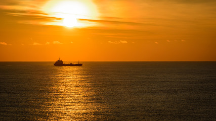 Naklejka na ściany i meble Ocean sunset and tanker on horizon