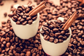 White espresso cups with coffee beans and cinnamon sticks