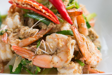 Stir-Fried Shrimp with Curry Powder in white plate on brown wood background