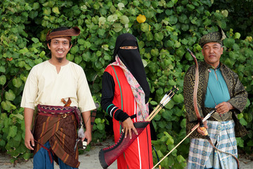 Southeast Muslim male and female archers complete with their traditional heritage clothes and...