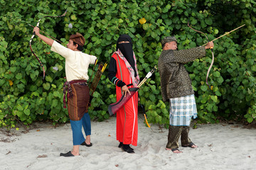 Southeast Muslim male and female archers complete with their traditional heritage clothes in action...