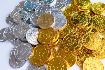 Among piles of golden and silver bitcoin on white background . Virtual cryptocurrency mining concept