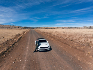 Man traveling by car on the desert road.